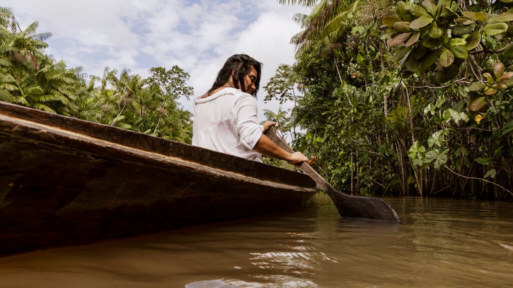 Turista remando um barco durante passeio na Rota Combú, Belém do Pará.
